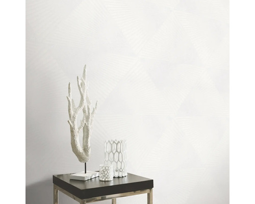 Scène décorative avec ornement corallien, bougeoirs et papier peint géométrique sur une table d''appoint.