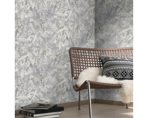 Dekorative Tapete mit Pflanzenmuster in einem hellen Raum mit Stuhl und Accessoires.