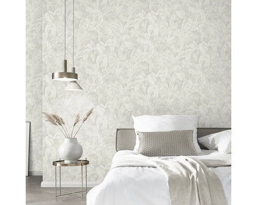 Schlafzimmer mit Bett, Nachttischlampe und Tapete mit Blättermuster