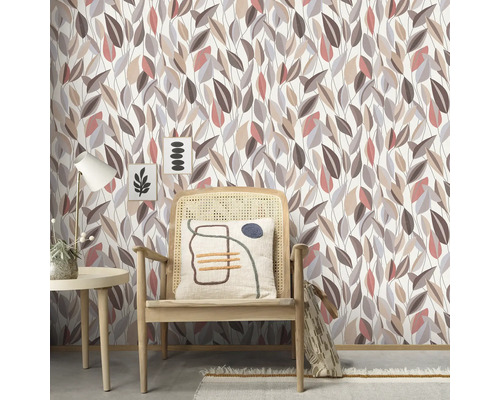 Wandgestaltung mit Blättermuster-Tapete, ergänzt durch Stuhl und Dekorationen