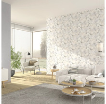 Salon lumineux avec papier peint à motifs, canapé et fauteuils