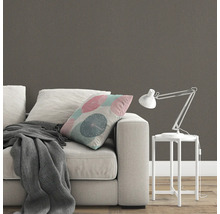 Scène avec canapé, coussin, couverture, lampe de table et papier peint à motifs