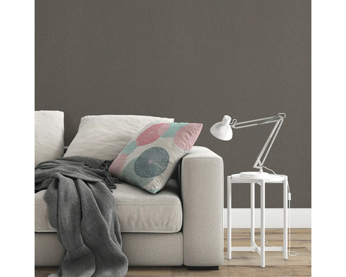 Szene mit Sofa, Kissen, Decke, Tischleuchte und gemusterter Tapete