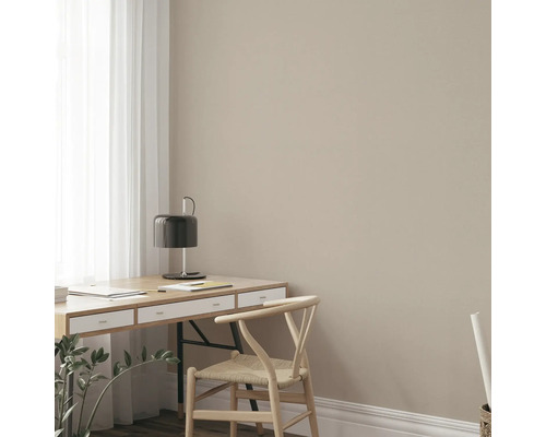 Schreibtisch mit Lampe und Holzstuhl in einem hellen Raum