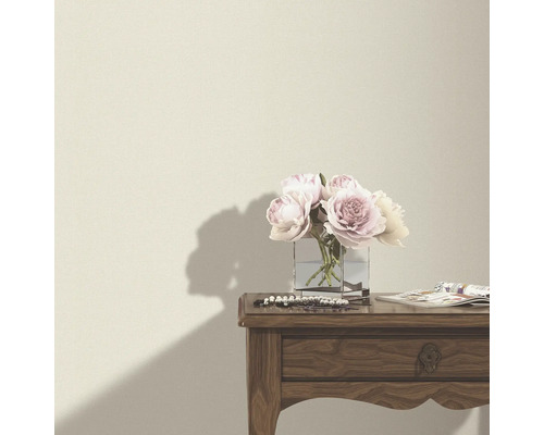 Dekorative Blumen auf einem Holztisch vor einer Wand