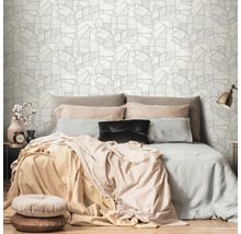 Schlafzimmer mit Bett und geometrischer Tapete im Hintergrund