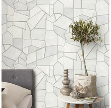 Wandgestaltung mit geometrischem Muster, Bett und Dekoration auf einem Tisch