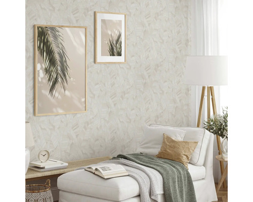 Wohnzimmer mit gemusterter Tapete, zwei gerahmten Bildern und weißem Sofa.