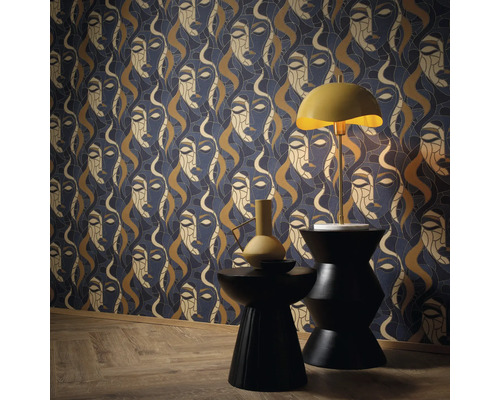 Dekorative Tapete mit Frauengesichtern, Tischleuchte und zwei Hockern im Raum.