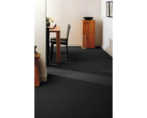 Salle à manger avec moquette sombre, table à manger et chaises.