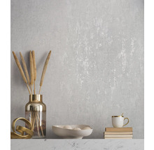 Dekorative Wand mit floralem Muster, Vase mit Pflanzen, Schale mit Deko-Elementen und Tasse auf Büchern
