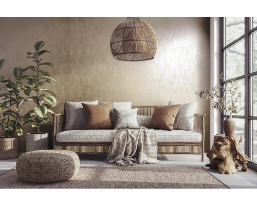 Salon avec canapé en rotin, coussins, tapis et plantes d''intérieur