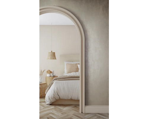 Scène de chambre lumineuse avec lit, table de chevet et suspension tressée, vue à travers une arche