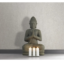 Statue décorative de Bouddha à côté de trois bougies