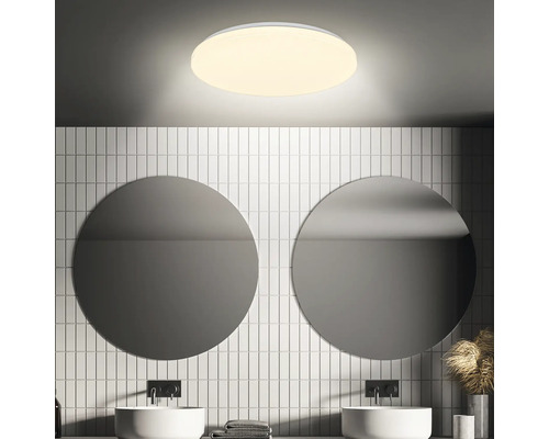 Badezimmer mit runden Spiegeln, Waschbecken und runder Deckenleuchte