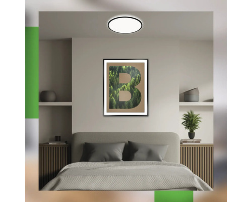 Schlafzimmer mit Doppelbett, Nachttischen und Wandbild mit einem B, das mit einem Waldbild gefüllt ist.