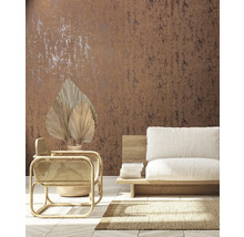 Wohnraum mit brauner Muster-Tapete, Rattan-Sessel und beigem Sofa