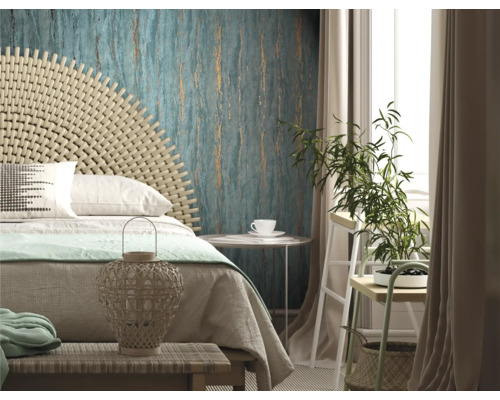 Helles Schlafzimmer mit Bett, Rattan-Kopfteil, gemusterter Tapete und Zimmerpflanze