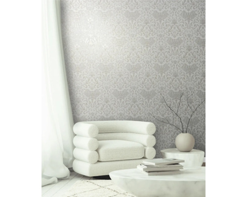 Helles Zimmer mit floral gemusterter Tapete, Sessel und Tisch