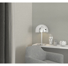 Modernes Wohnzimmer mit Sessel, Lampe und dekorativen Vasen auf einem Regal