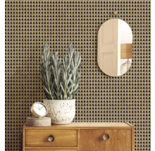 Dekorative Wandgestaltung mit Rattan-Tapete, Spiegel, Uhr, Pflanze und Holzkommode