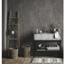 Badezimmer mit grauen Wandfliesen in Steinoptik, Waschbecken aus Beton, Holzleiter, Körben und gestreiftem Teppich