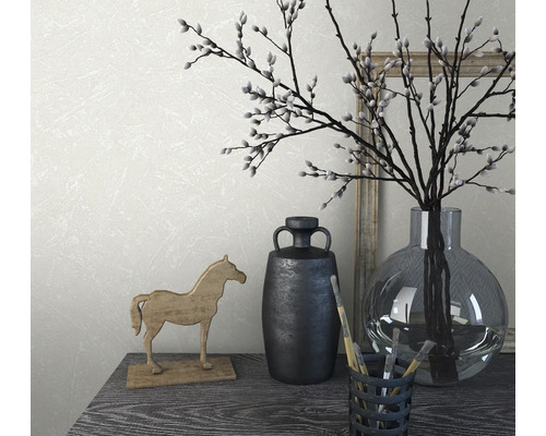 Arrangement décoratif avec vase, branches, figurine de cheval et pinceaux sur une table.