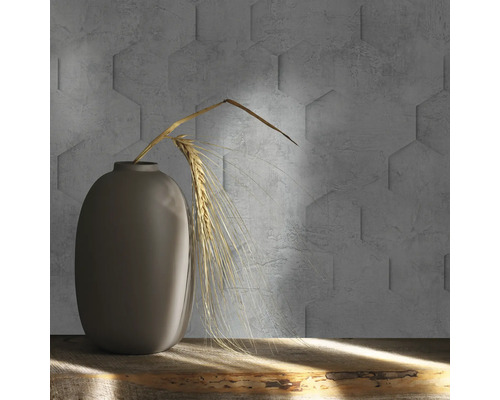 Vase grise décorative avec des épis de blé devant un mur avec des carreaux de béton hexagonaux