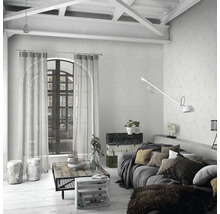 Salon lumineux avec canapé, table et rideaux dans une ambiance de loft