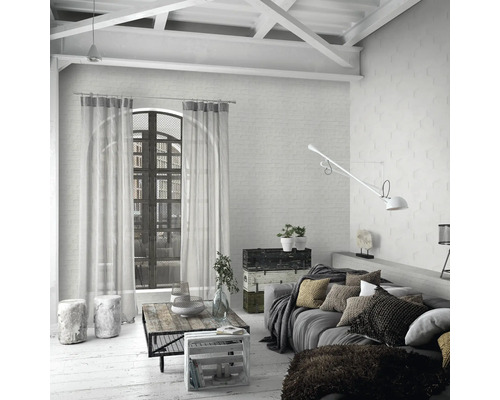 Salon lumineux avec canapé, table et rideaux dans une ambiance de loft