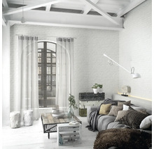 Salon lumineux avec canapé, table basse et baie vitrée