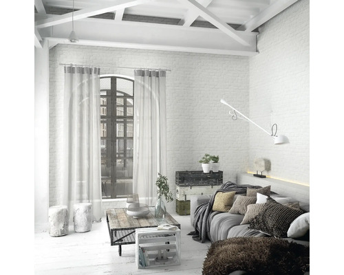 Salon lumineux avec canapé, table basse et baie vitrée