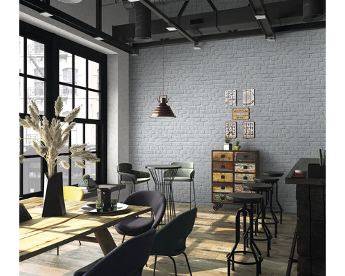 Heller Raum mit Backsteintapete, Holztisch und Stühlen