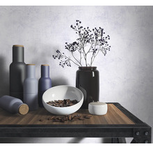 Arrangement décoratif avec bouteilles, bol et vase sur une étagère