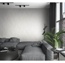 Salon avec canapé gris, lampadaire, plante d''intérieur et plafonniers.