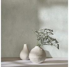 Deux vases décoratifs avec des fleurs séchées devant un mur