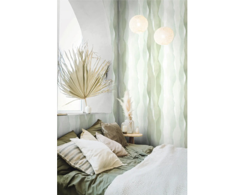 Chambre avec lit, coussins, table de chevet, décoration et papier peint à motifs.