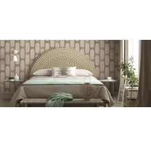 Helles Schlafzimmer mit geflochtenem Bettkopfteil, gemusterter Tapete und dekorativen Elementen.