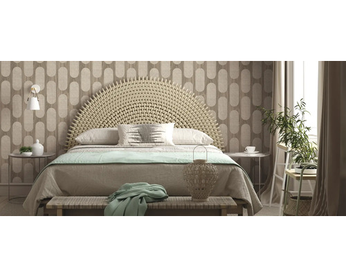 Helles Schlafzimmer mit geflochtenem Bettkopfteil, gemusterter Tapete und dekorativen Elementen.