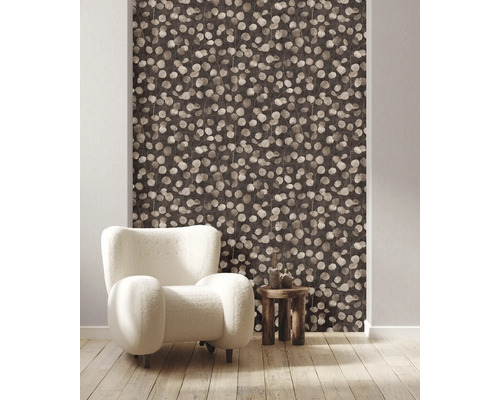 Vue d''une pièce avec papier peint à motifs de feuilles, fauteuil et table d''appoint