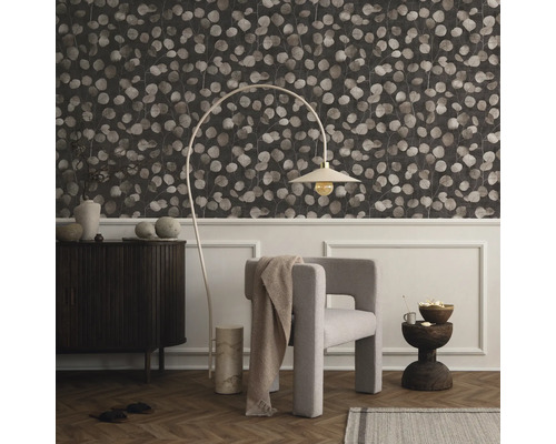 Salon avec papier peint à motifs, fauteuil, lampadaire et commode