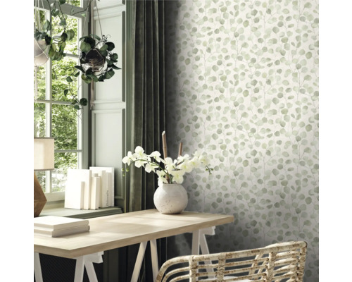 Scène avec un bureau, une fenêtre et un mur avec du papier peint eucalyptus.