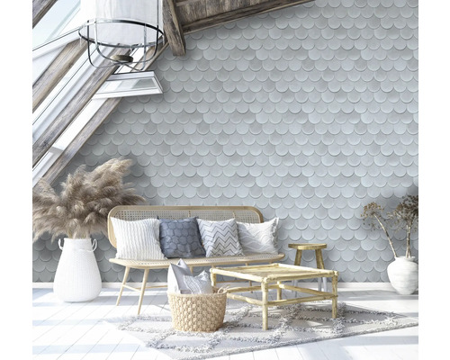Salon avec papier peint à écailles, meubles en rotin et accessoires décoratifs sous une fenêtre de toit
