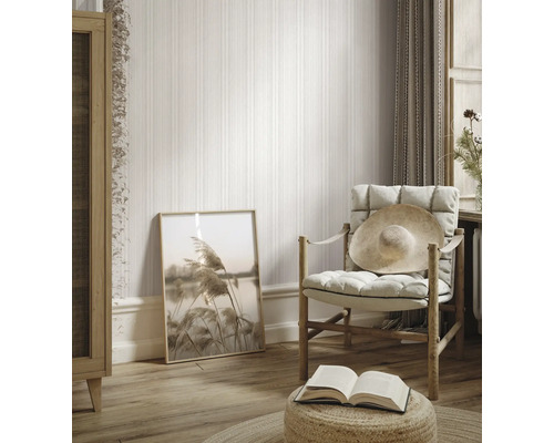 Pièce lumineuse avec papier peint rayé, fauteuil, image et décoration