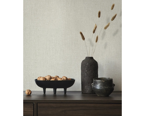 Scène décorative avec un bol de noix, un vase avec des herbes et un petit pot sur un buffet