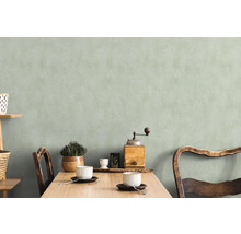Coin repas lumineux et accueillant avec table en bois, chaises, vaisselle et décoration devant un mur discret