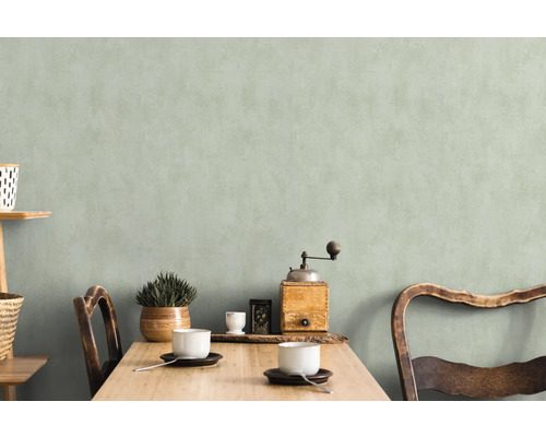 Coin repas lumineux et accueillant avec table en bois, chaises, vaisselle et décoration devant un mur discret