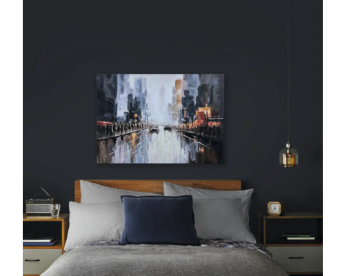Schlafzimmer mit Bett, Nachttischen und einem Gemälde mit Stadtmotiv über dem Bett.