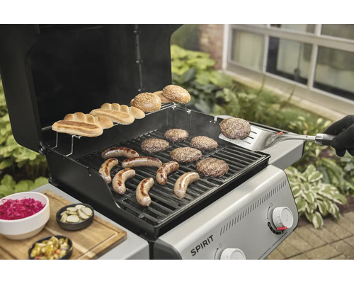 Barbecue à gaz avec saucisses, hamburgers et petits pains sur la grille