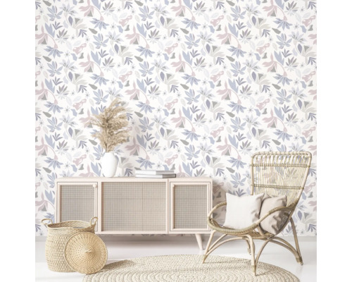 Wohnzimmer mit floraler Tapete, Sideboard, Rattansessel und rundem Teppich